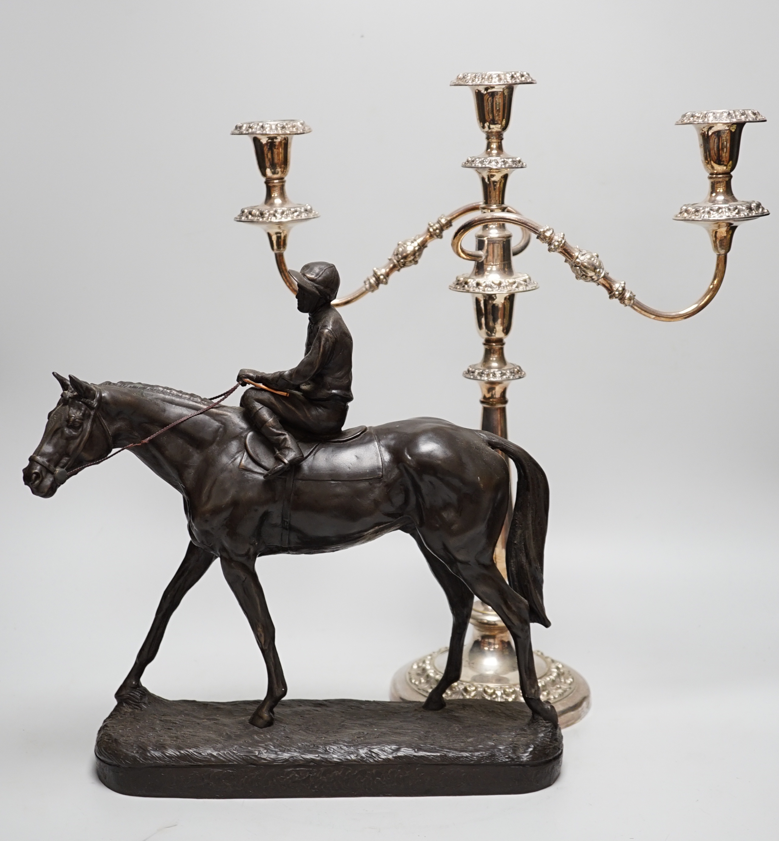 A bronzed resin racehorse and jockey group and a silver-plated three branch candelabrum -45cm high